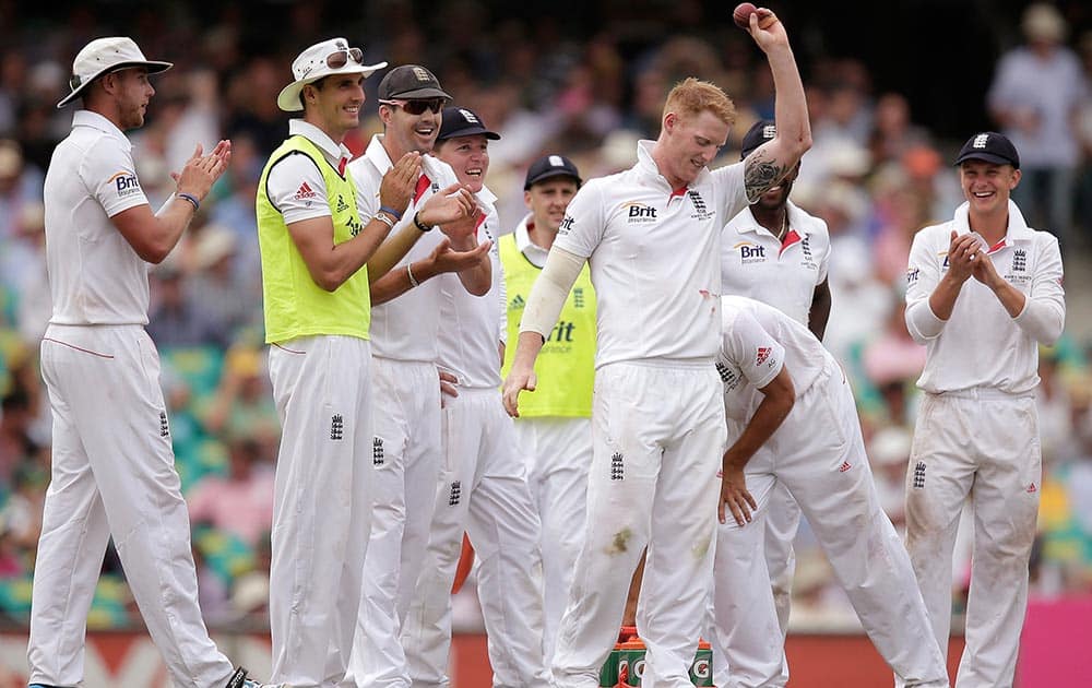 England's Ben Stokes, third right, holds up the ball after taking 5 wickets against Australia in their Ashes cricket test match at the Sydney Cricket Ground in Sydney.