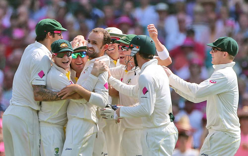 Australia's Nathan Lyon center, and teammates celebrate after taking the wicket of England's Scott Borthwick on the third day of their Ashes cricket test match in Sydney.