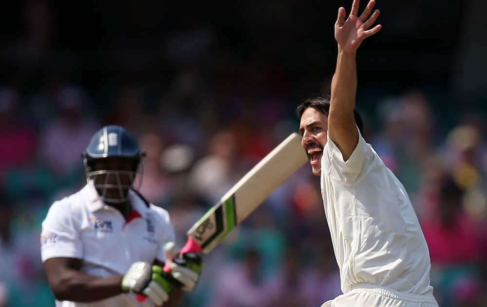 Australia's Mitchell Johnson, right, celebrates taking the wicket of England's Michael Carberry, left, for 43 runs on day 3 of their Ashes cricket test match at the Sydney Cricket Ground in Sydney.