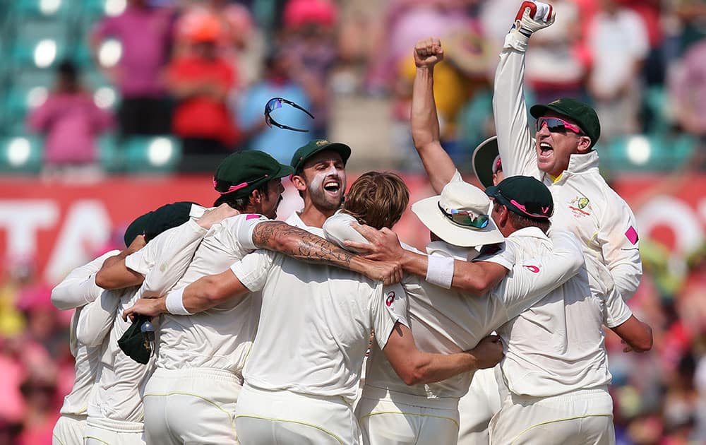 Australian teammates huddle at mid-wicket to celebrate their victory over England on day 3 of their Ashes cricket test match at the Sydney Cricket Ground in Sydney.