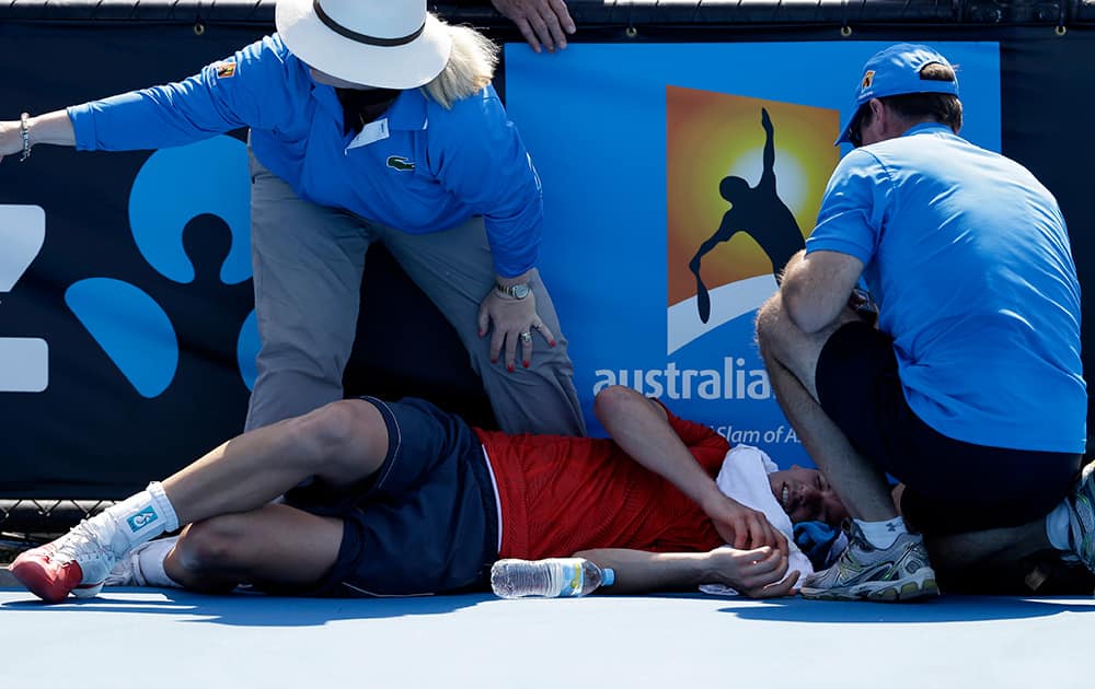 Frank Dancevic of Canada lies on the court after collapsing during his first round match against Benoit Paire of France as temperatures topped at 43 C (108 F) at the Australian Open tennis championship in Melbourne, Australia.