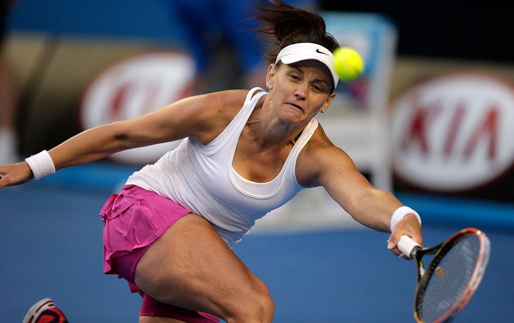 Casey Dellacqua of Australia makes a forehand return to Eugenie Bouchard of Canada during their fourth round match at the Australian Open tennis championship in Melbourne.