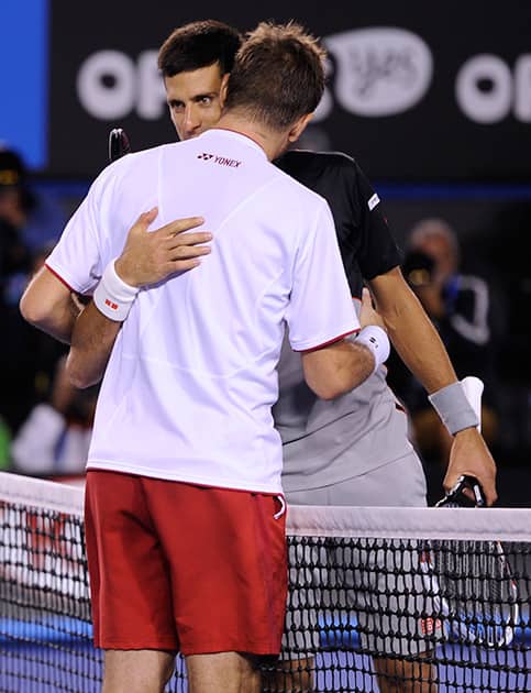 Stanislas Wawrinka of Switzerland hugs Novak Djokovic of Serbia at the net after Wawrinka won their quarterfinal at the Australian Open tennis championship in Melbourne, Australia.