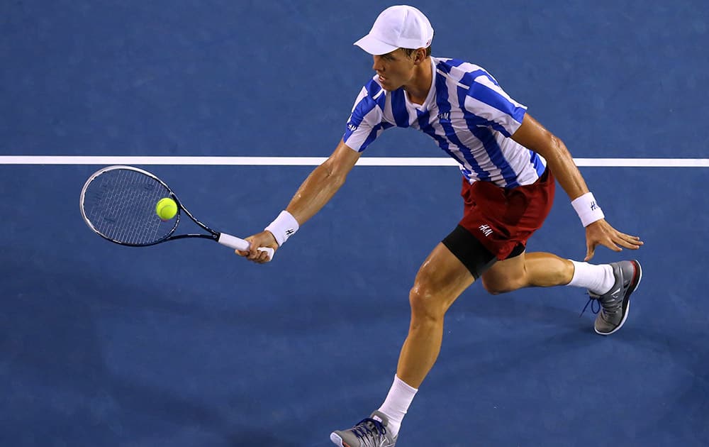 Tomas Berdych of the Czech Republic hits a return to Stanislas Wawrinka of Switzerland during their semifinal at the Australian Open tennis championship in Melbourne, Australia.