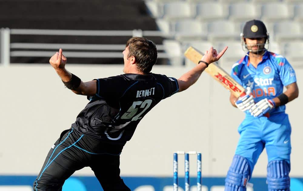 New Zealand's Hamish Bennett celebrates the dismissal of India’s Virat Kohli for 6 caught behind by Luke Ronchi in the third one-day International cricket match at Eden Park in Auckland.
