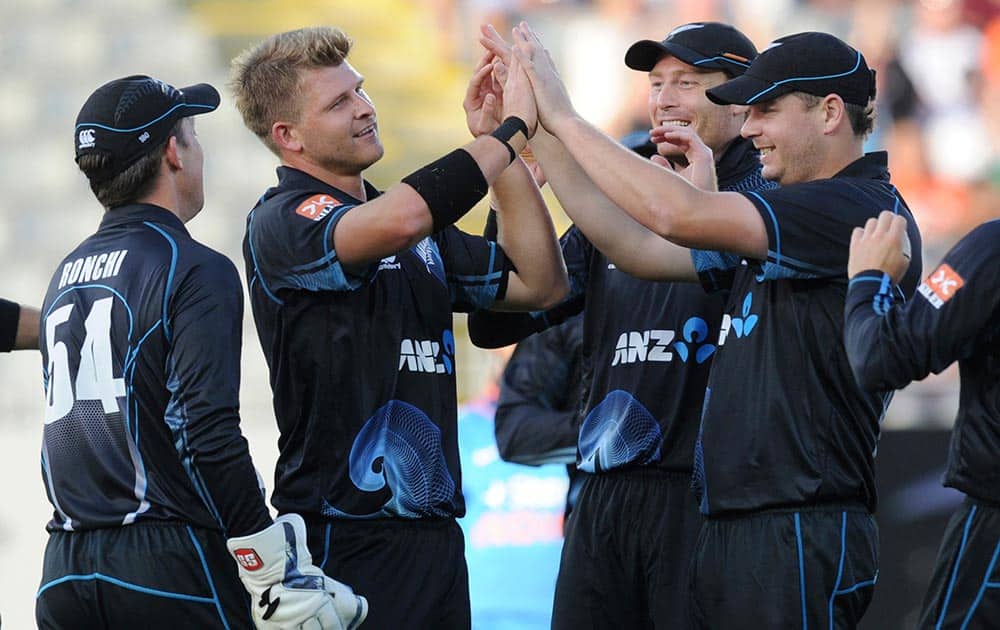 New Zealand's Corey Anderson, second from left, celebrates with teammates after dismissing India’s Ajinkya Rahane for 3 in their third one day international cricket match at Eden Park in Auckland.