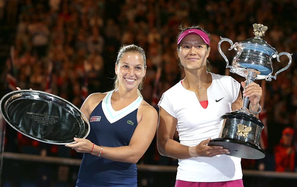 Li Na of China, holds the championship trophy with second placed Dominika Cibulkova of Slovakia in their women's singles final at the Australian Open tennis championship in Melbourne.