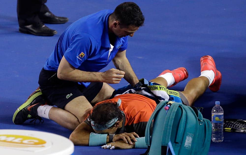 Rafael Nadal of Spain receives a medical treatment to his back as he plays Stanislas Wawrinka of Switzerland during the men's singles final at the Australian Open tennis championship in Melbourne.