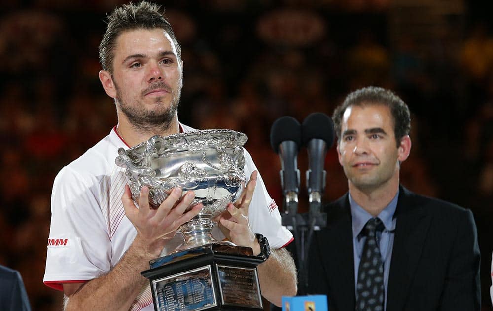 Stanislas Wawrinka of Switzerland holds the trophy after defeating Rafael Nadal of Spain, beside Pete Sampras, in the men's singles final at the Australian Open tennis championship in Melbourne.
