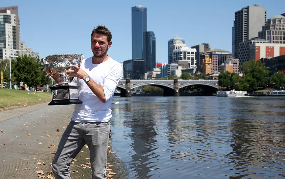 SWITZERLAND`S STANISLAS WAWRINKA POSES WITH HIS AUSTRALIAN OPEN TROPHY ON THE BANKS OF THE YARRA RIVER FOLLOWING HIS WIN OVER SPAIN`S RAFAEL NADAL ON SUNDAY EVENING IN MELBOURNE.