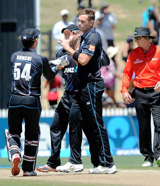 New Zealand's Tim Southee, right, celebrates after dismissing India’s Virat Kohli for 2 in the fourth one-day international cricket match at Seddon Park in Auckland.