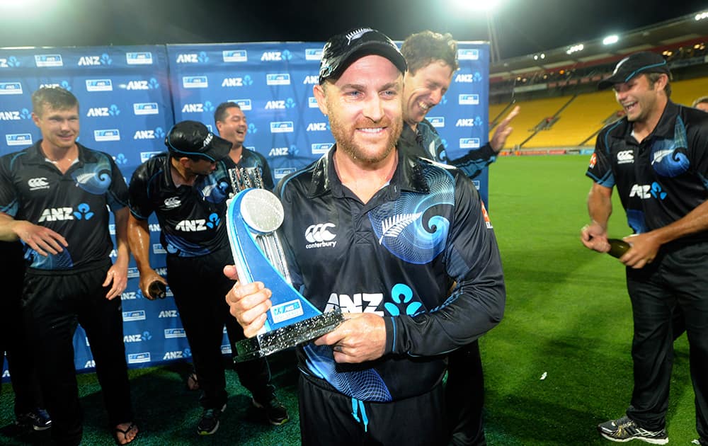 New Zealand's captain Brendon McCullum holds the trophy as his teammates celebrate after their series' victory over India during the fifth one day International cricket match at Westpac Stadium in Wellington, New Zealand.