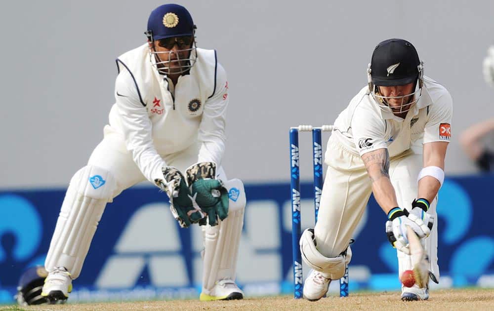 New Zealand’s Brendon McCullum bats in front of India’s wicket keeper MS Dhoni on the first day of the first cricket test at Eden Park in Auckland, New Zealand.