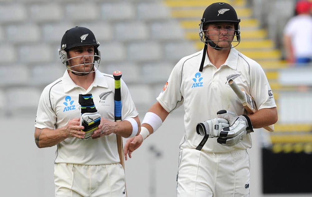 New Zealand’s Brendon McCullum, left, leaves the pitch 143 not out with Corey Anderson at the end of play against New Zealand on the first day of the first cricket test at Eden Park in Auckland, New Zealand.