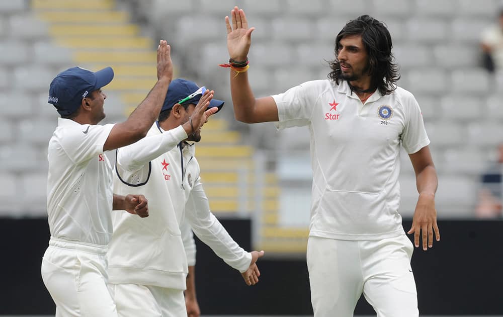 India’s Ishant Sharma gives high five with team mates after dismissing New Zealand’s BJ Watling for 1 on the second day of the first cricket test at Eden Park in Auckland, New Zealand.