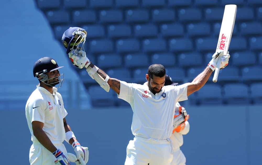 India’s Shikar Dhawan celebrates his century watched by Virat Kohli against New Zealand on the fourth day of the first cricket test at Eden Park in Auckland, New Zealand.