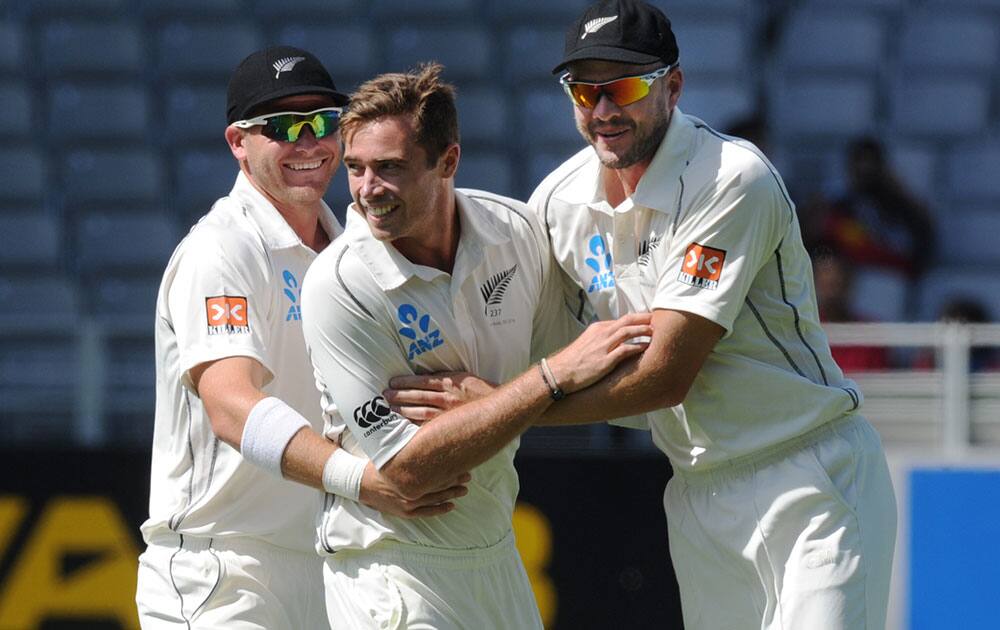 New Zealand’s Tim Southee, center, with Corey Anderson, left and Peter Fulton after dismissing India’s Rohit Sharma for 19 on the fourth day of the first cricket test, at Eden Park in Auckland, New Zealand.
