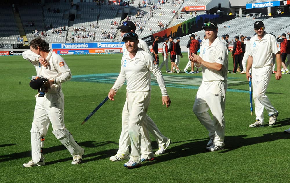 New Zealand’s Brendon McCullum, center, walks with his team after their 40 run defeat of India on the fourth day of the first cricket test at Eden Park in Auckland, New Zealand.