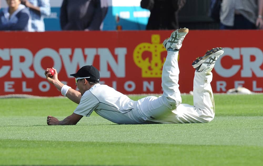 New Zealand’s Trent Boult holds up the ball after taking a diving catch to dismiss India’s Ajinkya Rahane for 118 on the second day of the second cricket test in Wellington, New Zealand.