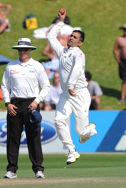 India’s MS Dhoni changes wicket keeper pads to bowl an over against New Zealand on the 4th day of the 2nd cricket test at Basin Reserve in Wellington, New Zealand.