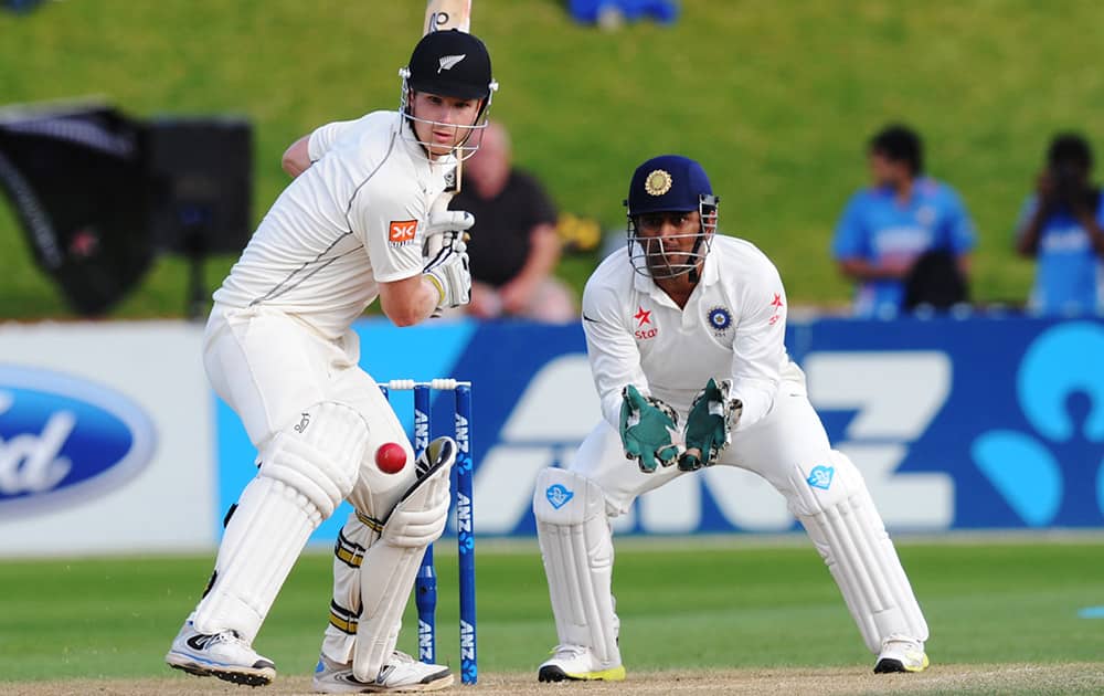 New Zealand's James Neesham bats in front of India’s wicketkeeper MS Dhoni on the fourth day of their second cricket test mat at Basin Reserve in Wellington, New Zealand.