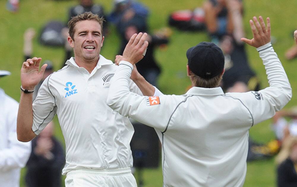 New Zealand’s Tim Southee, left, celebrates with Tom Latham after dismissing India’s Murali Vijay for 7 on the final day of the second test at the Basin Reserve in Wellington, New Zealand.