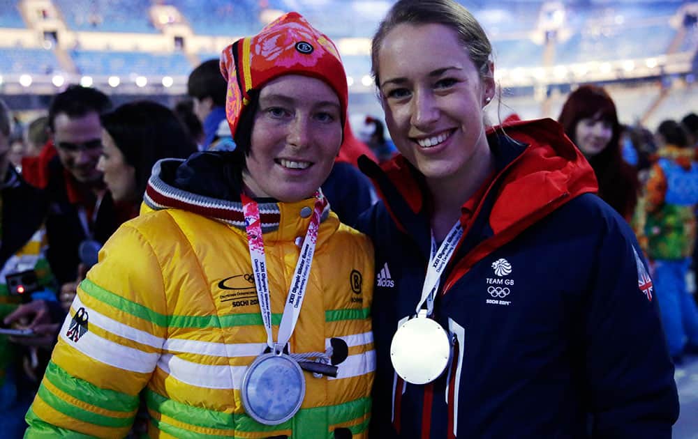 Britain's Elisabeth Yarnold, right, and Germany's Marion Thees pose for a photograph during the closing ceremony of the 2014 Winter Olympics.
