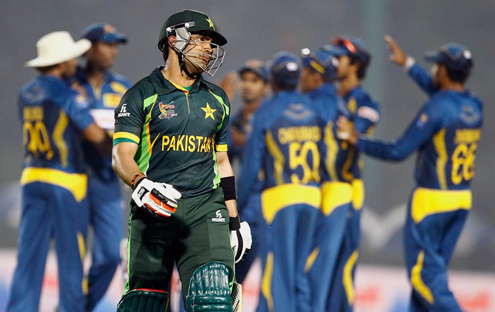 Pakistan’s Umar Akmal, foreground, walks back to the pavilion after his dismissal by Sri Lanka’s Suranga Lakmal during the opening match of the Asia Cup one-day international cricket tournament between them in Fatullah, near Dhaka, Bangladesh.