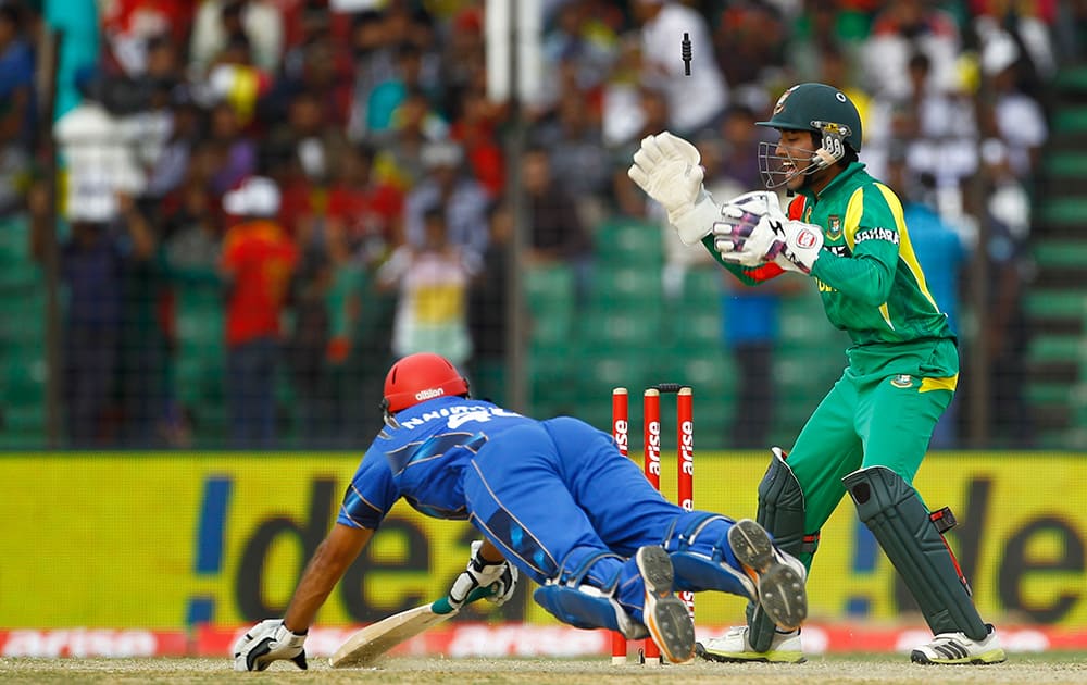 Bangladesh’s Naeem Islam, unseen, successfully dislodges the bails to dismiss of Afghanistan’s Nawroz Mangal during the Asia Cup one-day international cricket tournament between them in Fatullah, near Dhaka, Bangladesh.
