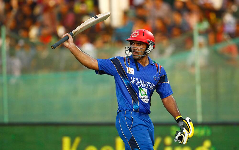 Afghanistan’s Samiullah Shenwari acknowledges the crowd as he walks back to the pavilion after his dismissal during the Asia Cup one-day international cricket tournament against Bangladesh in Fatullah, near Dhaka, Bangladesh.