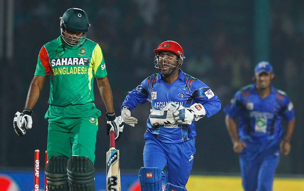 Afghanistan’s wicketkeeper Mohammad Shahzad, center, celebrates the wicket of Bangladesh’s Ziaur Rahman during the Asia Cup one-day international cricket tournament in Fatullah, near Dhaka, Bangladesh.