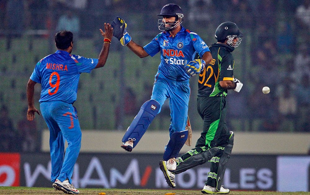Dinesh Karthik, center, celebrates with teammate the wicket of Pakistan’s Sohaib Maqsood during the Asia Cup one-day international cricket tournament between them in Dhaka, Bangladesh.