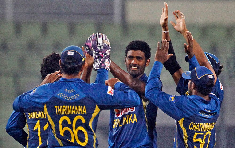 Sri Lanka’s Thisara Perera, center, celebrates with teammates after taking the wicket of Afghanistan’s Nawroz Mangal during the Asia Cup one-day international cricket tournament between them in Dhaka.