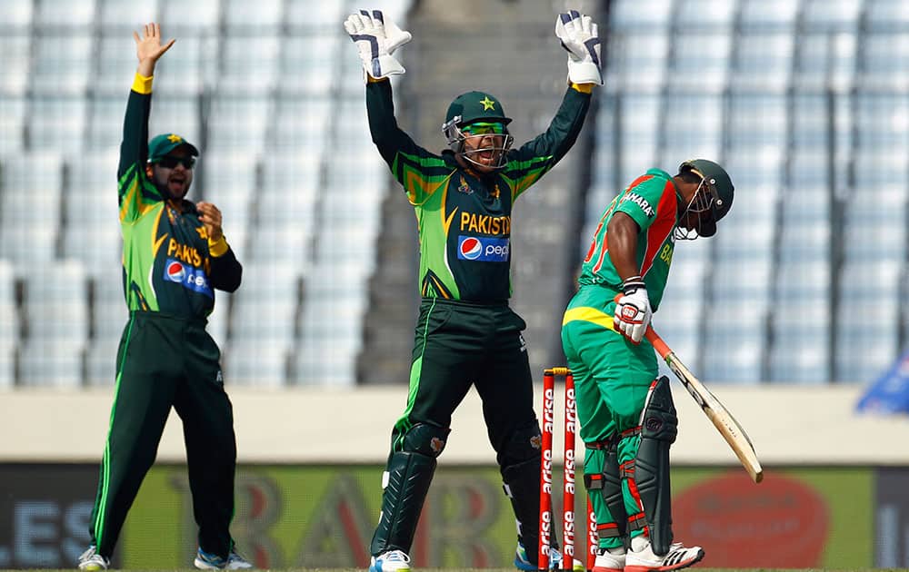 Pakistan’s wicketkeeper Umar Akmal, center, makes an unsuccessful appeal for the dismissal of a Bangladeshi cricket player during the Asia Cup one-day international cricket tournament in Dhaka.