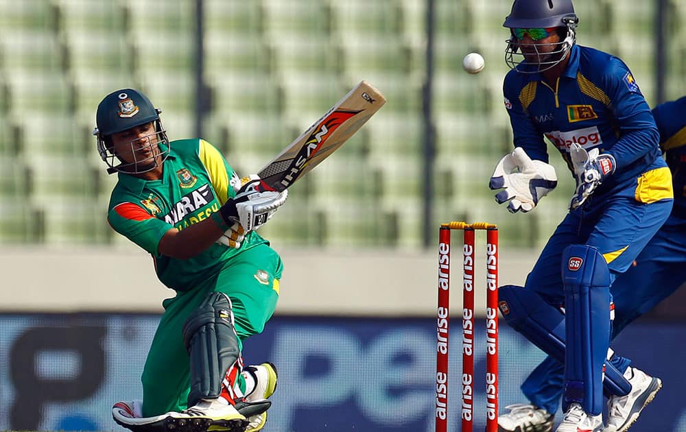 Bangladesh’s Shamsur Rahman, left, bats as Sri Lankan cricketer Kumar Sangakkara watches during the Asia Cup one-day international cricket tournament in Dhaka, Bangladesh.