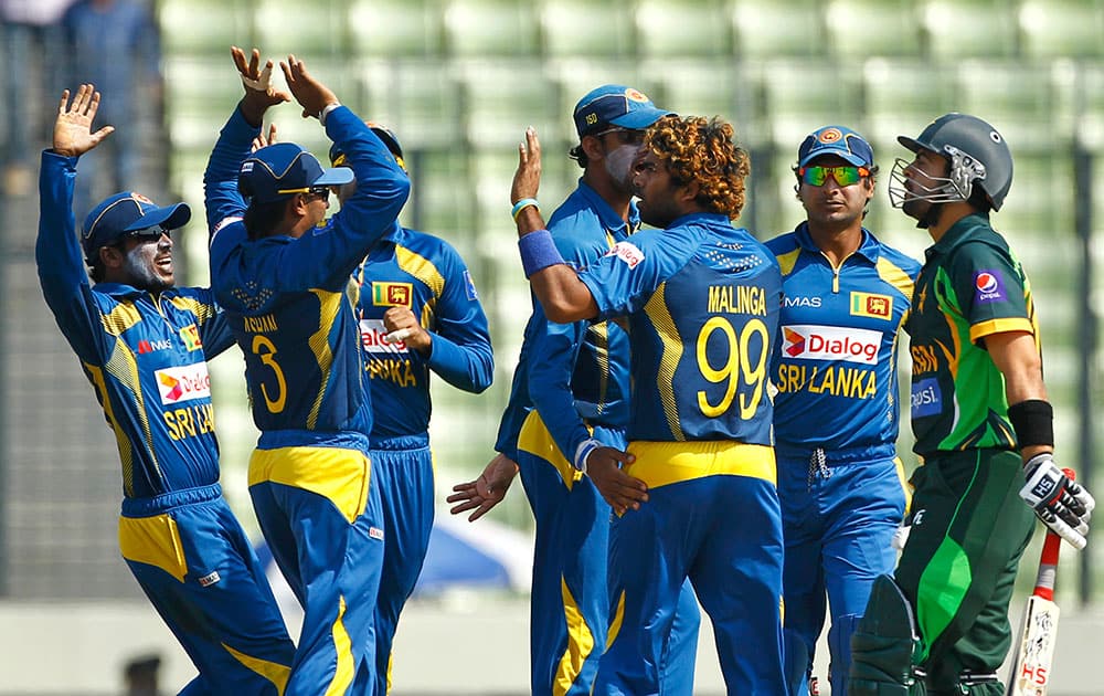 Sri Lankan cricket player Lasith Malinga, third right, celebrate with his teammates after taking the wicket of Pakistan’s Ahmed Shehzad, right, during the Asia Cup final cricket match against Pakistan in Dhaka.