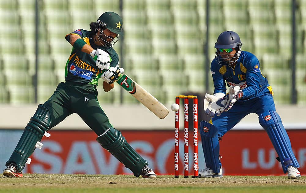 Pakistan’s Fawad Alam, left, plays a shot in front of Sri Lankan wicketkeeper Kumar Sangakkara during their Asia Cup final cricket match in Dhaka.