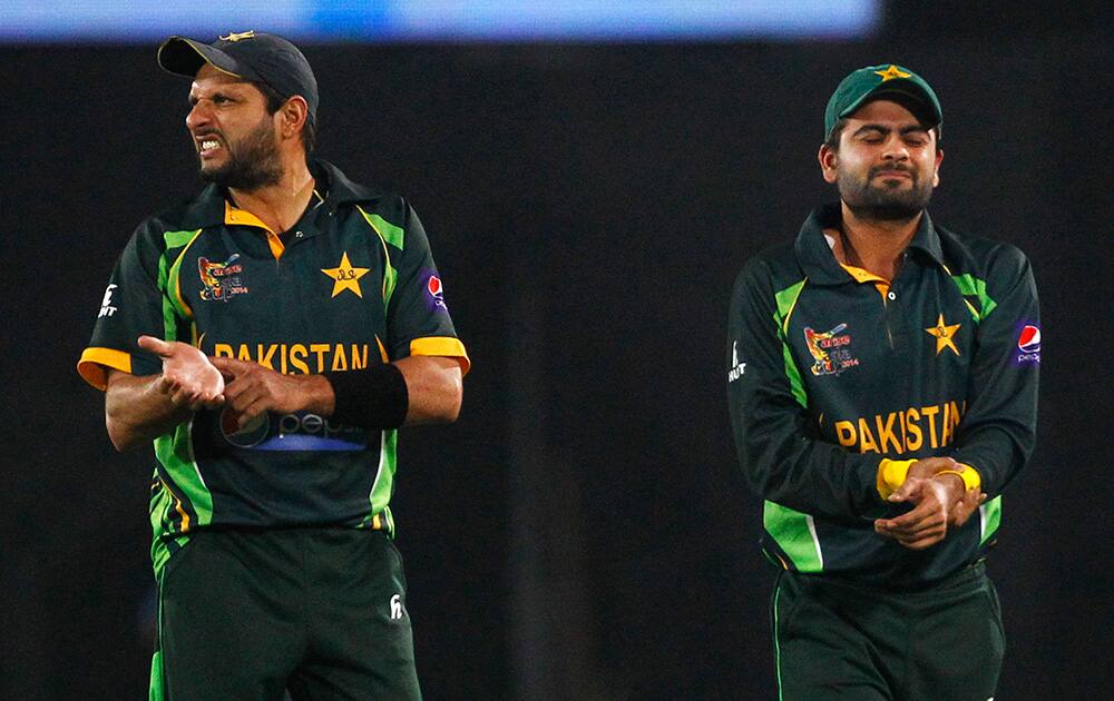 Pakistan’s Shahid Afridi points towards his wrist to indicate an injury on teammate Ahmed Shehzad during the Asia Cup final cricket match between Sri Lanka and Pakistan in Dhaka, Bangladesh.