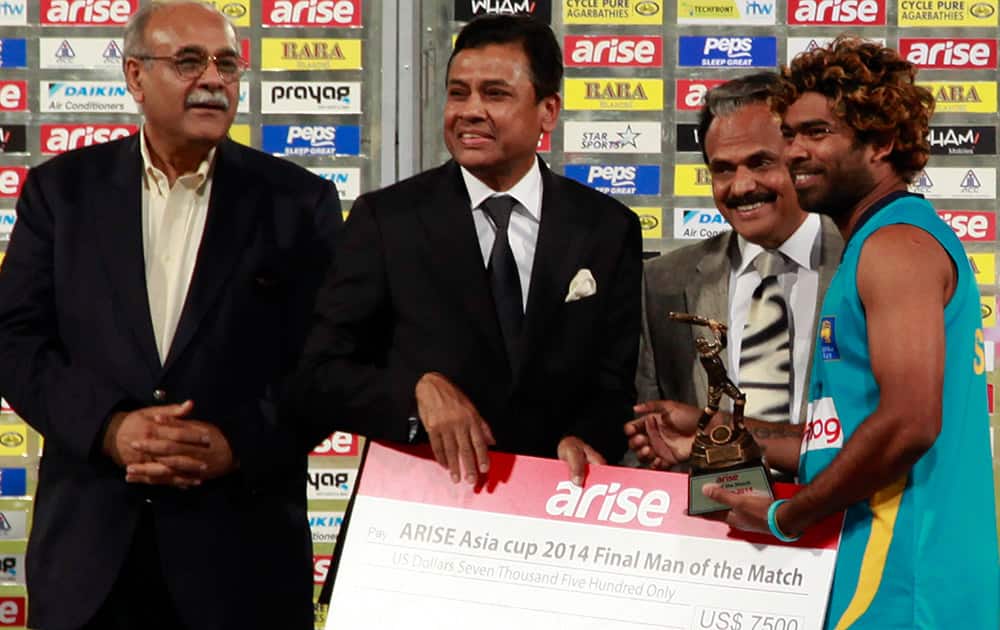 Sri Lankan cricketer Lasith Malinga, right, holds the Man of the Match trophy after the Asia Cup final match against Pakistan in Dhaka, Bangladesh.