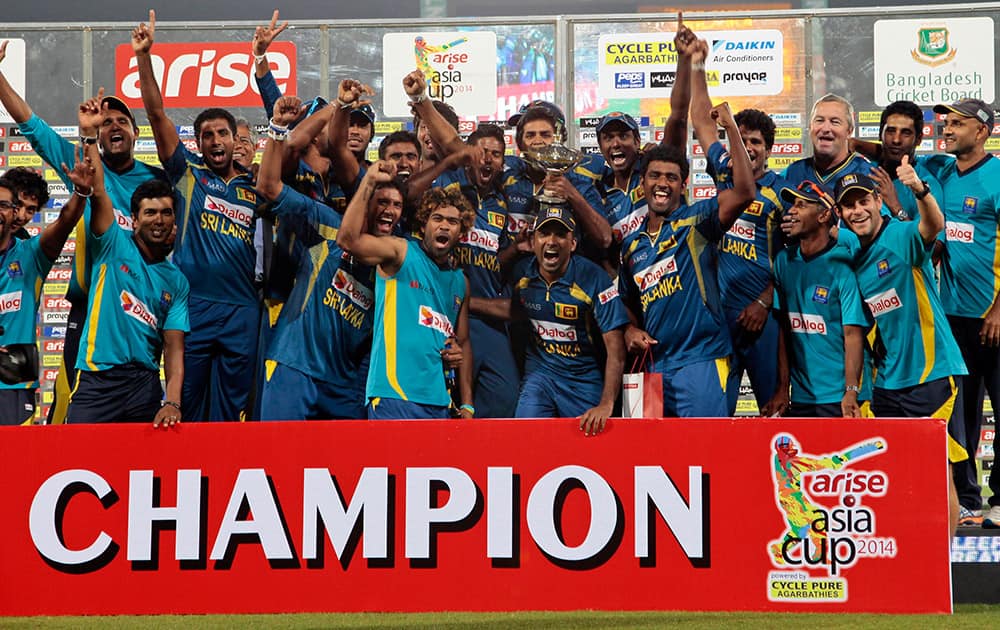 Sri Lankan cricketers and support staff celebrate with the trophy after winning the Asia Cup final match against Pakistan in Dhaka, Bangladesh.