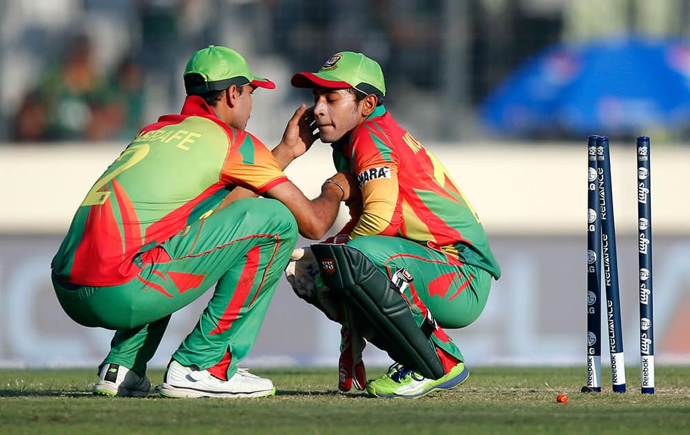 Bangladesh's Mashrafe Mortaza, left, attends to captain Mushfiqur Rahim after a ball hit Rahim on his face during their ICC Twenty20 Cricket World Cup opening match against Afghanistan in Dhaka.