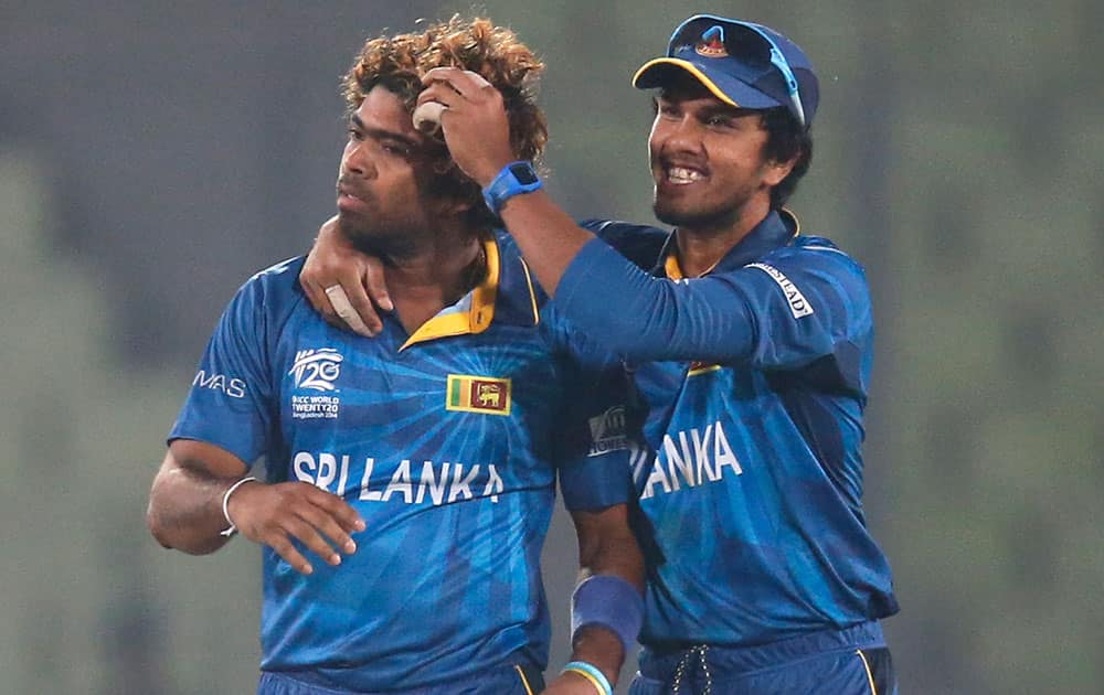 Sri Lanka's bowler Lasith Malinga, left, celebrates with captain Dinesh Chandimal after the dismissal of India's batsman Virat Kohli during their ICC Twenty20 Cricket World Cup warm up match in Dhaka, Bangladesh.