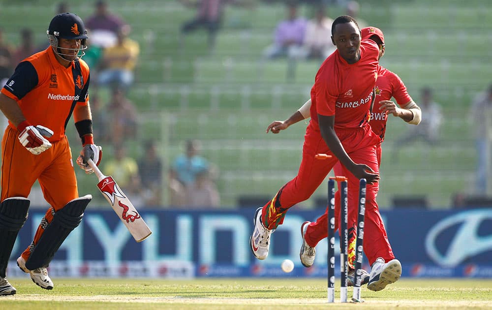Zimbabwe's Tendai Chatara, right, successfully dislodges the bails to dismiss the Netherlands' Michael Swart, left, during their ICC Twenty20 Cricket World Cup match in Sylhet, Bangladesh.