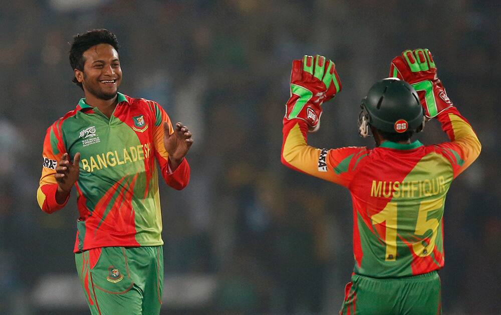 Bangladesh bowler Shakib Al Hasan, left, celebrates with captain Mushfiqur Rahim, right, the dismissal of West Indies' batsman Lendl Simmons during their ICC Twenty20 Cricket World Cup match in Dhaka, Bangladesh.