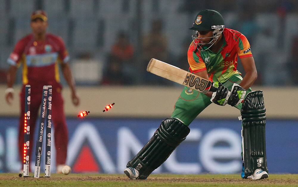 Bangladesh's last batsman Sohag Gazi is bowled out by West Indies' bowler Andre Russell during their ICC Twenty20 Cricket World Cup match against West Indies' in Dhaka, Bangladesh. West Indies' won the match by 73 runs.