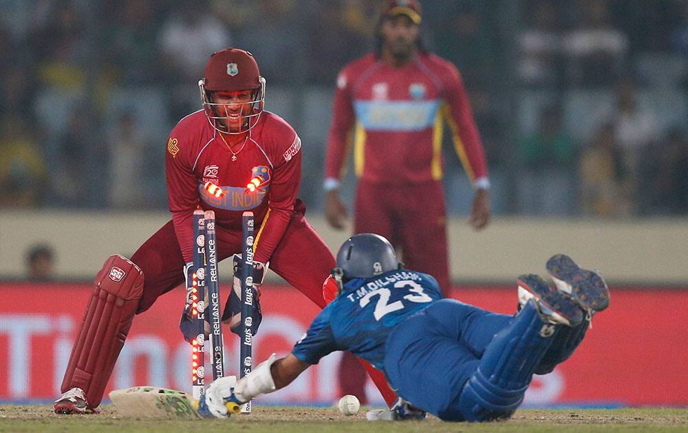 Sri Lanka's batsman Tillakaratne Dilshan, on ground, is run out by West Indies' Lendl Simmons, unseen, as wicketkeeper Denesh Ramdin looks on during their ICC Twenty20 Cricket World Cup semi-final match in Dhaka.