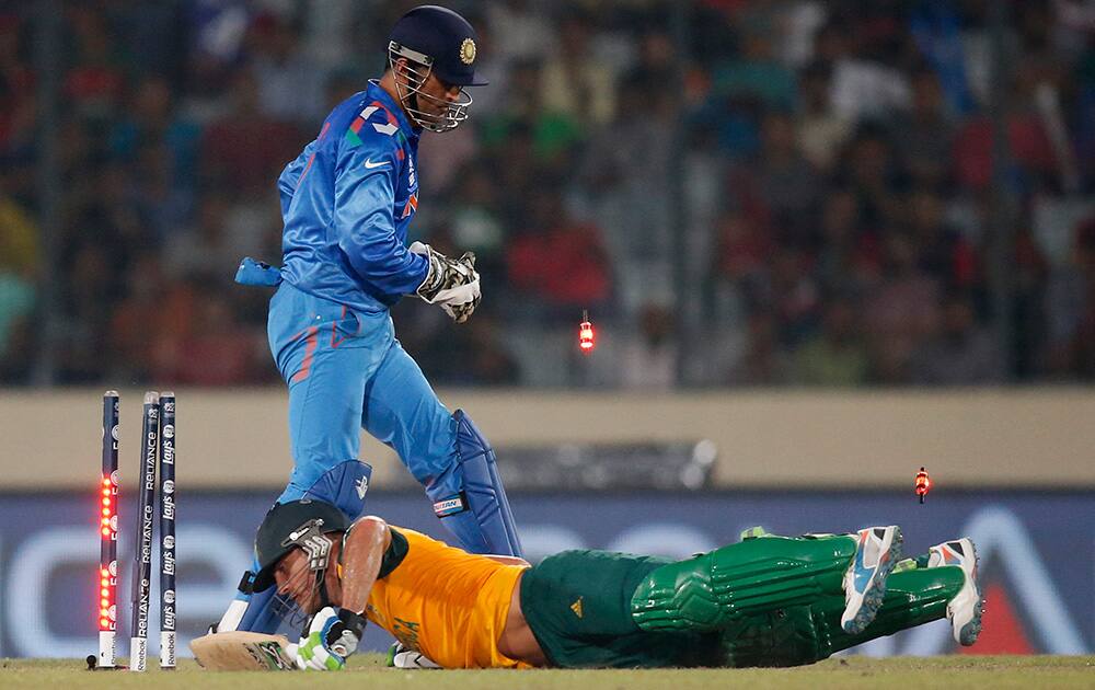 South Africa's captain Francois du Plessis falls on the ground after India's captain Mahendra Singh Dhoni attempted to run out Plessis during their ICC Twenty20 Cricket World Cup semi-final match in Dhaka, Bangladesh.