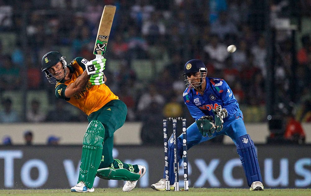 South Africa's captain Francois du Plessis, left, plays a shot, as India's captain Mahendra Singh Dhoni watches during their ICC Twenty20 Cricket World Cup semifinal match in Dhaka, Bangladesh.