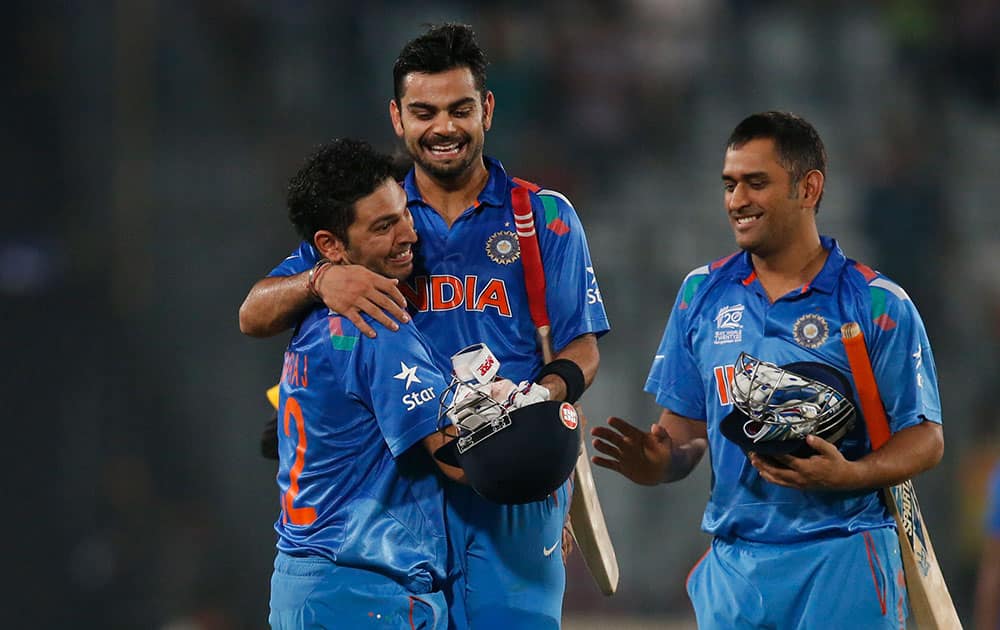 Yuvraj Singh, lifts teammate Virat Kohli to celebrate their win over South Africa in the ICC Twenty20 Cricket World Cup semi-final match in Dhaka, Bangladesh. India won the match by six wickets. On the right is captain Mahendra Singh Dhoni.