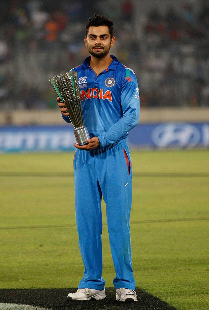 India's Virat Kohli poses with the Player of the Tournament trophy after his team's loss in the ICC Twenty20 Cricket World Cup final match against Sri Lanka in Dhaka.